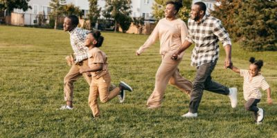 Dad  and mom playing with kids outside