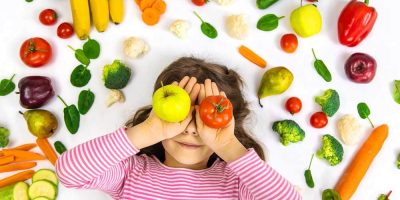 A child with vegetables and fruits in their hands. Selective focus. Food.; Shutterstock ID 1934668004; purchase_order: 31/03/2022; job: TEY newsletter 1